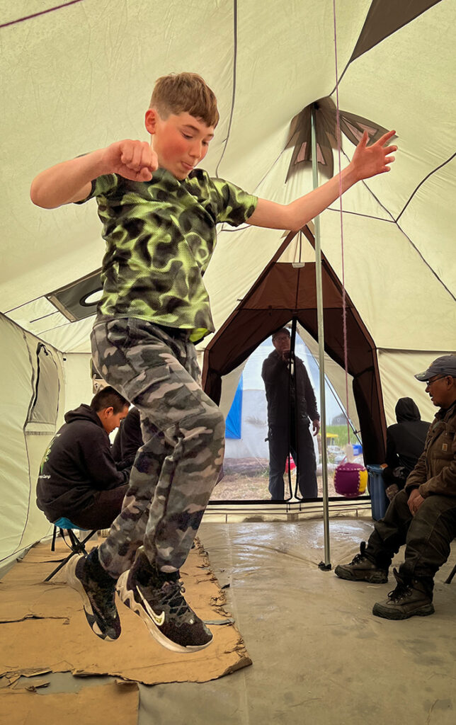 Yuuyaraq camper practicing the One-Foot High Kick with a Native Youth Olympics ball sewn at the culture camp.
